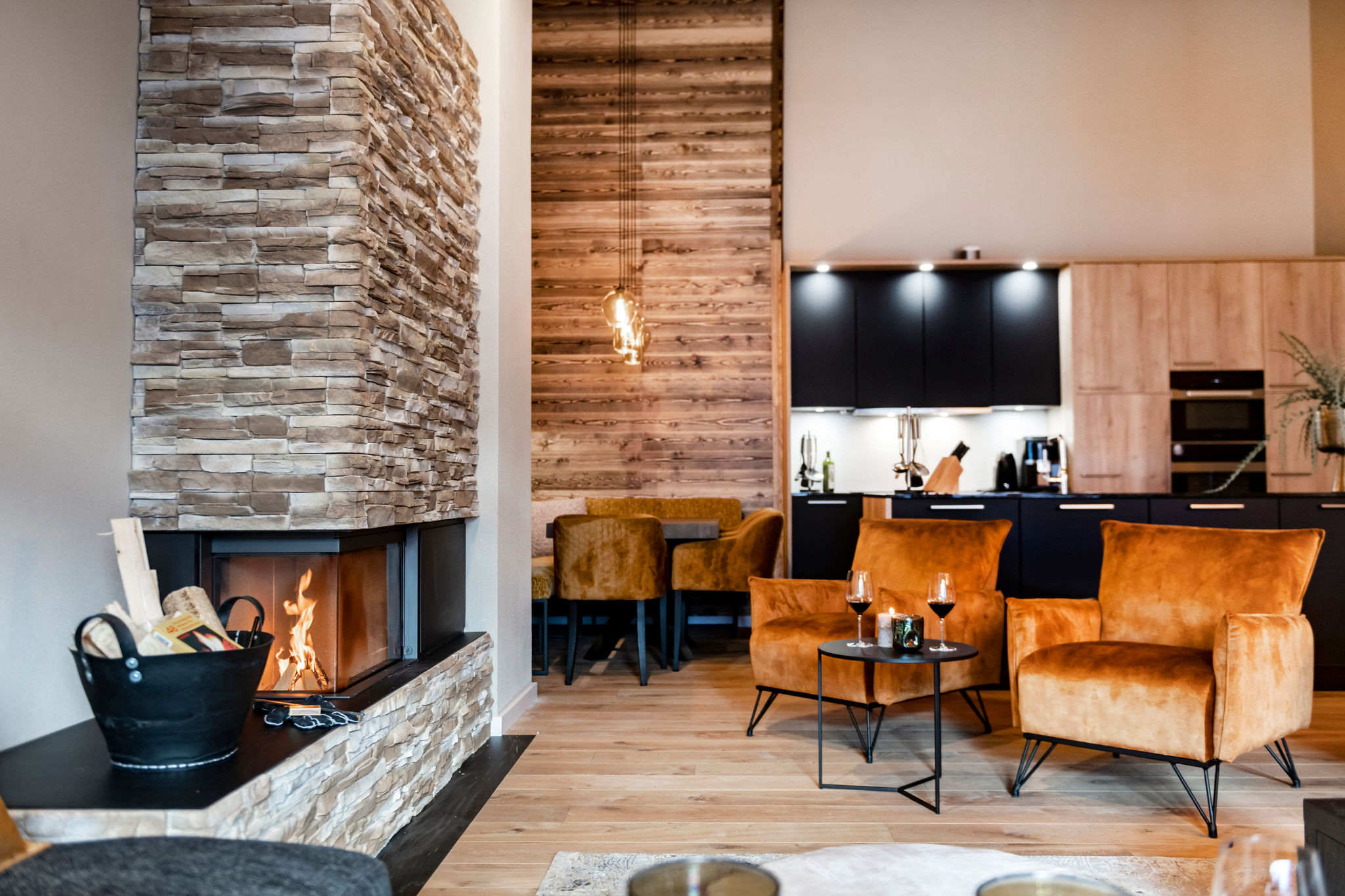 Een moderne woonkamer met open haard en houten vloer in een appartement in Oostenrijk.